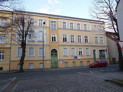 Ein dreigeschossiges Stadthaus mit zwei Eingängen und einer Toreinfahrt, ca. 100 Jahre alt, steht an der ruhigen Dahmer Straße gegenüber der Einmündung zur Gartenstraße in Luckenwalde.