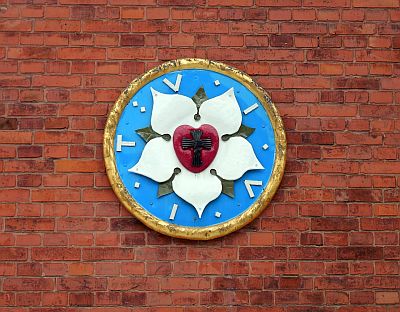 An einer Klinkermauer prangt die Lutherrose.