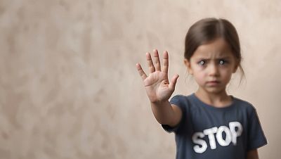 Ein Mädchen streckt uns abwehrend ihre offene Hand entgegen. Die Hand ist scharf abgebildet. Das Gesicht des Mädchens ist unscharf, dennoch können wir angstvoll geöffnete Augen und einen verstörten, aber auch entschlossenen Gesichtsausdruck erkennen. Das T-Shirt des Mädchens hat einen Aufdruck "STOP". Es handelt sich um ein von sogenannter künstlicher Intelligenz erzeugtes Bild, das etwas mystisch wirkt, wie viele von KI erzeugte Bilder.